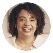 Smiling woman with curly hair wearing a white top, set against a circular coral background. Represents positivity, confidence, and Noom’s diverse and supportive user community.
