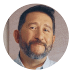 Smiling man with short dark hair and a beard, wearing a light-colored shirt, framed in a circular coral background. Represents trust, experience, and Noom’s supportive member community.